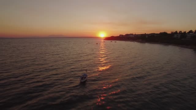 Aerial-Sonnenuntergang-Szene-der-See-mit-Booten-und-Ferienort-an-der-Küste,-Griechenland