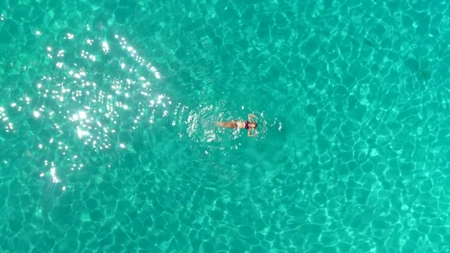 Luftaufnahme-einer-Frau,-die-im-Meer-der-Insel-Atokos,-Griechenland,-schwimmt