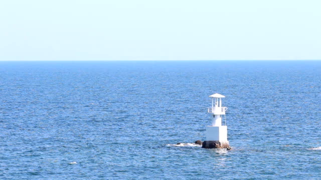 Leuchtturm-im-Meer,-mit-blauem-Himmel