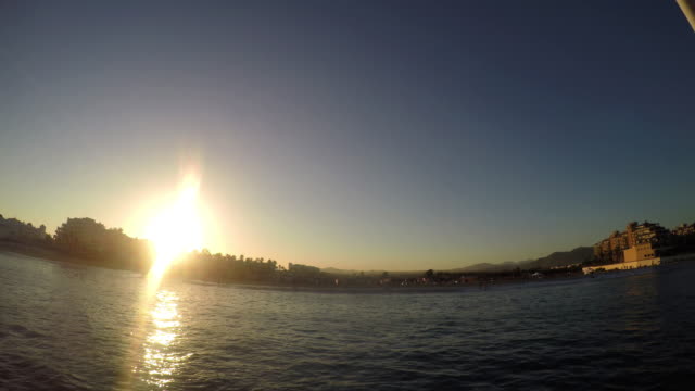 Ansicht-eines-Stadt-an-der-Küste-ein-Sonnenuntergang,-von-einem-Boot-auf-dem-Meer