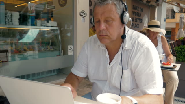 Hombre-escribiendo-en-Computadora-Portátil,-auriculares