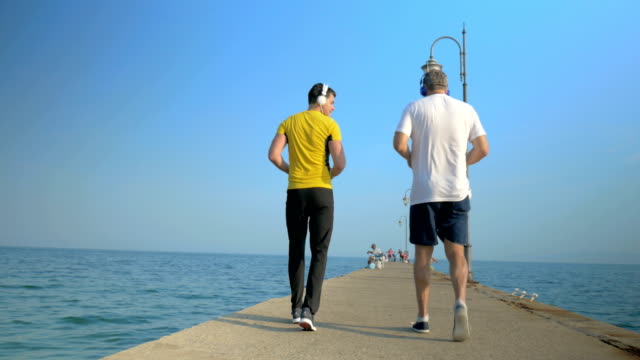Men-exercising-by-walking-backward-along-the-pier