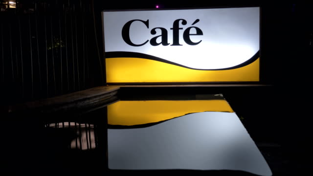 Beleuchtete-Café-Banner-in-der-Nacht