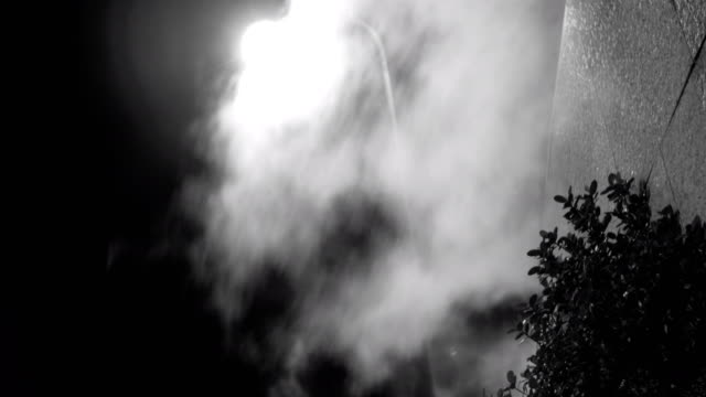 Steam-against-street-lantern-light-at-night,-mystic-black-and-white-shot