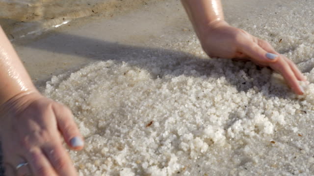 Frau-Hände-nehmen-Salz-vom-Ufer-des-Toten-Meeres