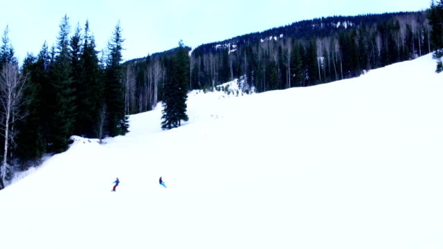 Menschen,-die-Snowboarden-auf-verschneiten-Bergen