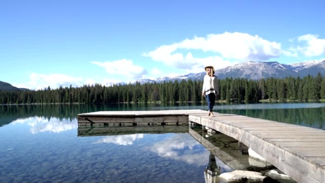 Frau-zu-Fuß-über-Pier-stehen-über-atemberaubende-Gebirgssee-in-den-kanadischen-rockies