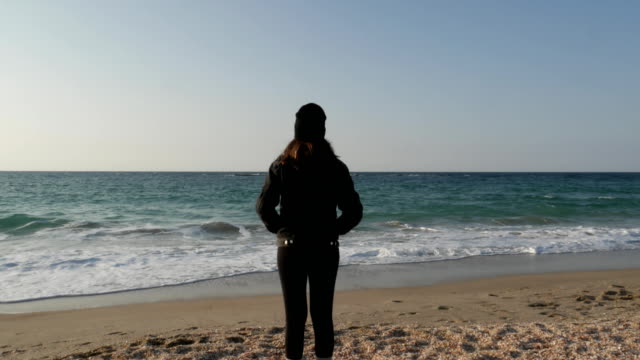 Mädchen-steht-am-Ufer-des-Mittelmeers-an-einem-kalten-Herbsttag