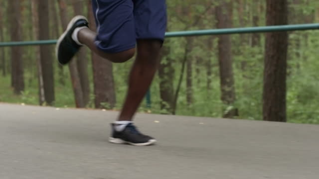Beine-der-schwarze-Mann-läuft-auf-Forststraße