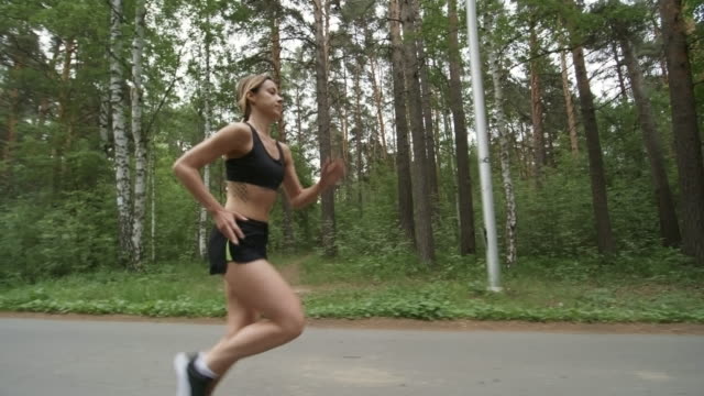 Sporty-Woman-Running-along-Forest-Road
