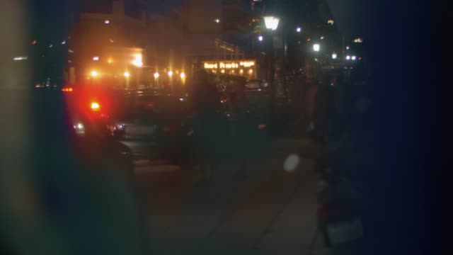 Am-Abend-Stadtstraße-mit-Menschen-und-Autos,-Blick-durchs-Glas
