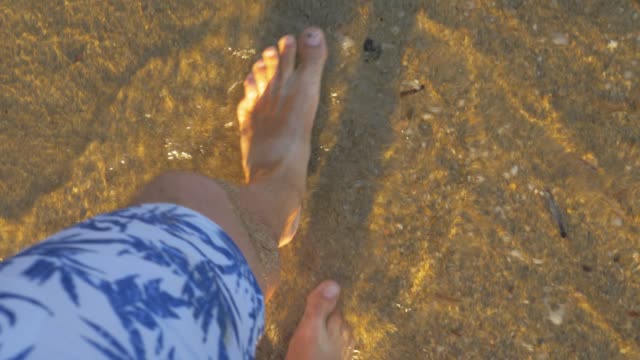 Urlauber-zu-Fuß-entlang-der-Küste-des-Meeres-und-der-Wellen-seine-Füße-zu-waschen