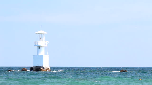 Leuchtturm-im-Meer,-mit-blauem-Himmel