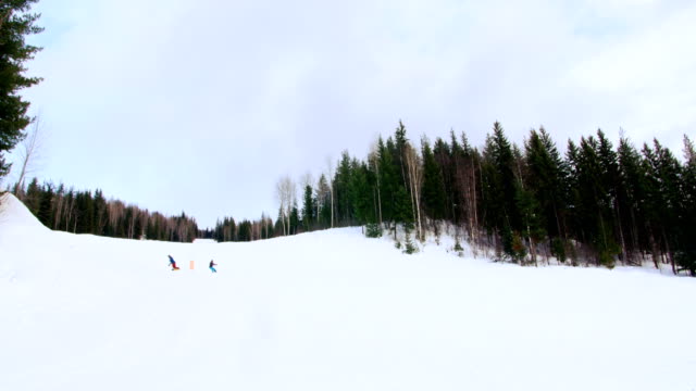 People-snowboarding-on-snowy-mountain
