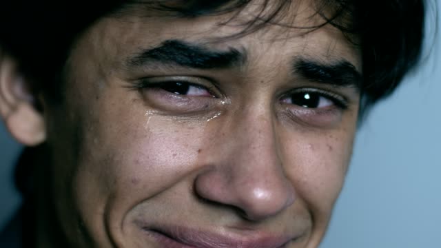 Sad-desperate-young-man-crying-looking-at-camera--macro