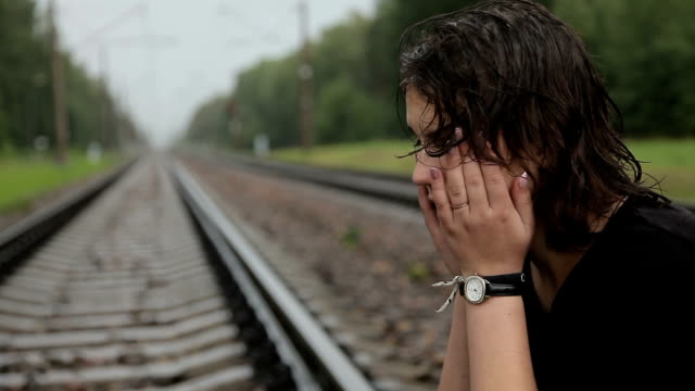 Teen-girl-cries-on-the-railroad-tracks