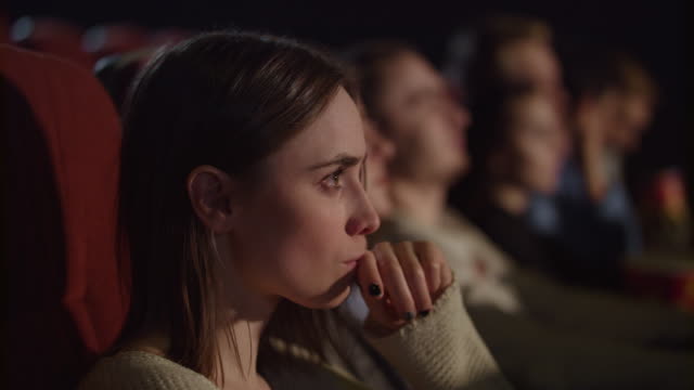 Concentrated-girl-watching-thrilling-movie-at-cinema.-Enjoy-cinema-concept