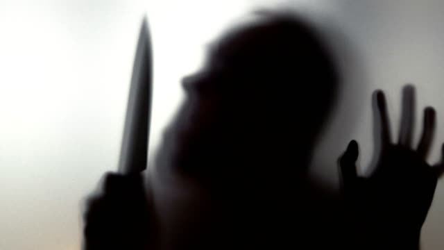Man-with-knife-behind-frosted-glass-in-4k-slow-motion-60fps