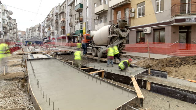 Concrete-works-for-road-maintenance-construction-with-many-workers-and-mixer-timelapse