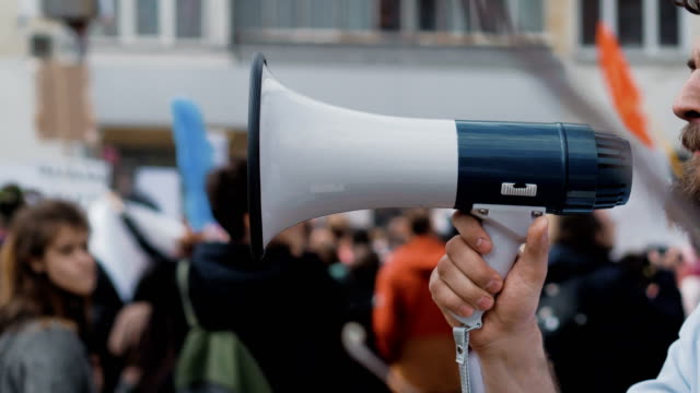 Young-adult-man-shouts-in-megaphone.-Caucasian-people-shout-violently-and-angry.