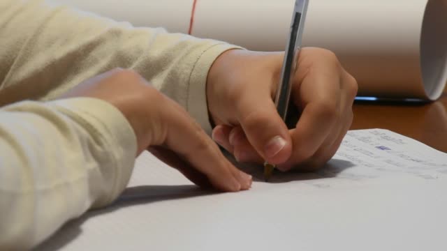 Hand-der-linkshändige-junge-schreiben-Hausaufgaben
