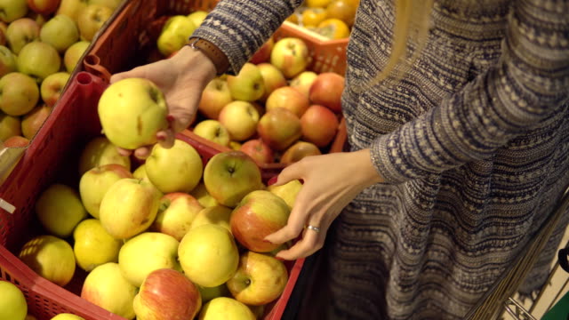 Hände-von-Frau-Wahl-Apfel-Obst-Gemüse-Supermarkt