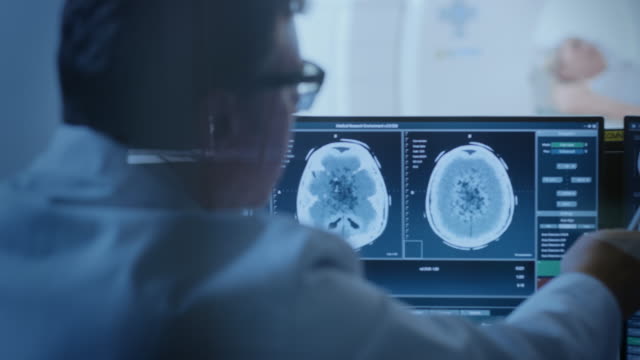 Im-medizinischen-Labor-Patient-erfährt-MRT-oder-CT-Scan-Vorgang-unter-Aufsicht-des-Radiologen-im-Kontrollraum,-er-wacht-Verfahren-und-Monitore-Gehirn-Aktivität-Ergebnisse.