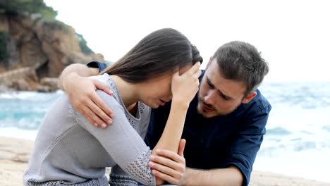 Man-comforting-to-his-sad-friend-on-the-beach