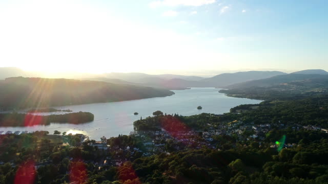 Aerial-shot-moving-back-from-the-houses-on-the-lakeshore-and-surrounding-countryside-at-Lake-Windermere,-Lake-District,-UK