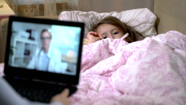 Mom-with-a-little-sick-daughter-gets-a-doctor's-consultation-using-video-chat-at-home.