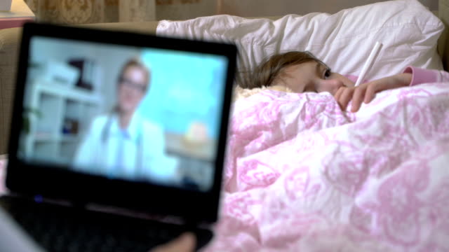 Mamá-con-una-hija-enferma-obtiene-la-consulta-de-un-doctor-utilizando-el-chat-de-video-en-casa.