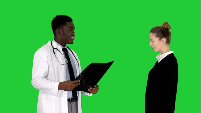 Médico-que-a-un-paciente-los-resultados-de-rayos-x-luego-paciente-sale-en-una-pantalla-verde-Chroma-Key