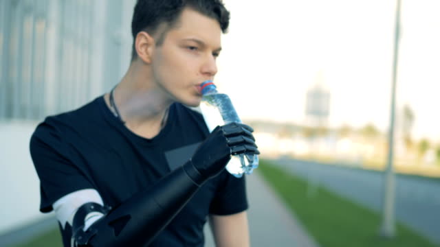Körperlich-behinderte-Menschen-ist-Trinkwasser-mit-seinem-futuristischen-bionische-Hand.