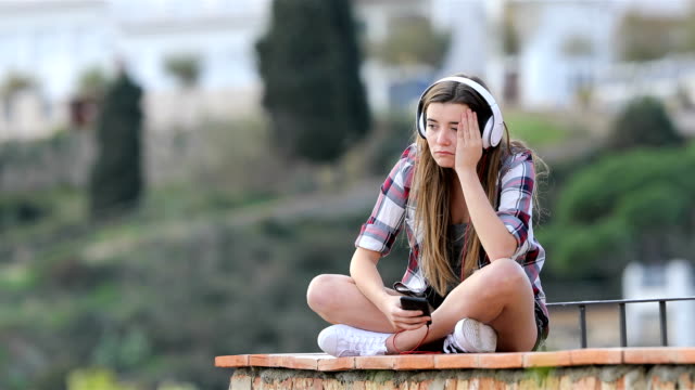 Triste-adolescente-escuchando-música-en-vacaciones