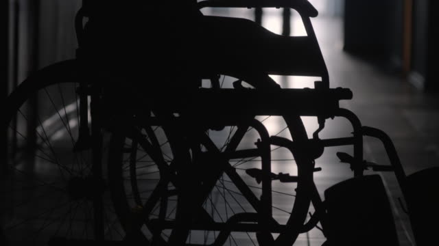 Silhouette-des-Mannes-an-Rollstuhl-entlang-Krankenhausflur-hinken