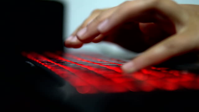 Dedos-taping-teclado-de-la-luz-roja-Notebook-ordenador-portátil.-Tecnología-para-el-éxito-del-emprendimiento-tecnológico-programador-de-la-tecnología-de-la-información-en-sala-oscura.-Home-Work-Computing-empresario-hacker