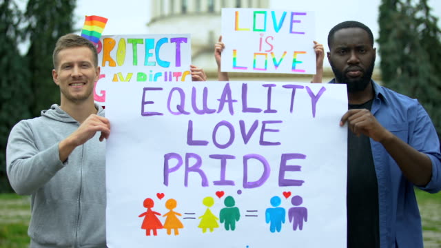 Man-raising-Equality-love-pride-poster-together-with-LGBT-activists,-pride-march