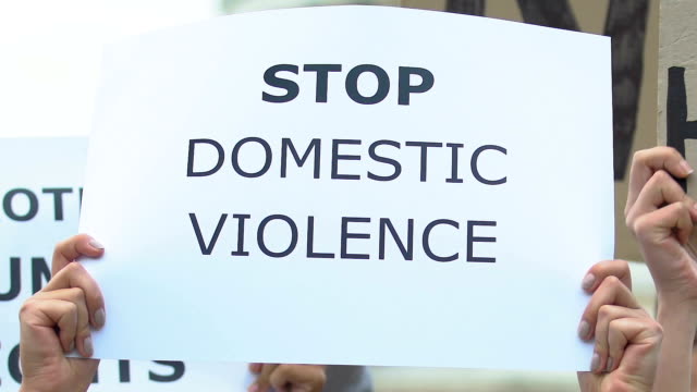Banner-mit-dem-Slogan-Stoppt-häusliche-Gewalt-in-Aktivistenhand,-Kundgebung-gegen-Missbrauch