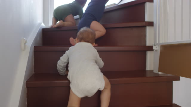 Bebé-trillizos-subiendo-escalera-hacia-mamá-en-casa