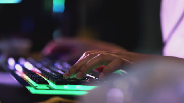 Nahaufnahme-von-Teenager-Mädchen-mit-Händen-auf-beleuchtete-Tastatur-Gaming-zu-Hause-in-der-Nacht