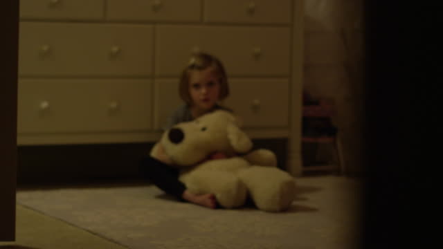 Trauriges-junges-Mädchen-sitzt-auf-dem-Boden-ihres-Schlafzimmers-allein-hält-ein-Stofftier