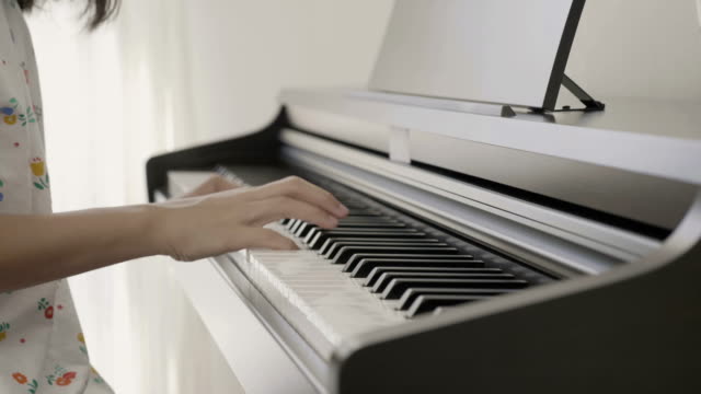 4K:-Slow-Motion-der-Asiatin-spielt-Klavier,-Pan-Schuss