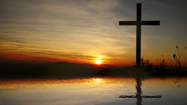 Cross-of-Jesus-Christ-near-Water-with-Sunset-and-Peaceful-Mood.