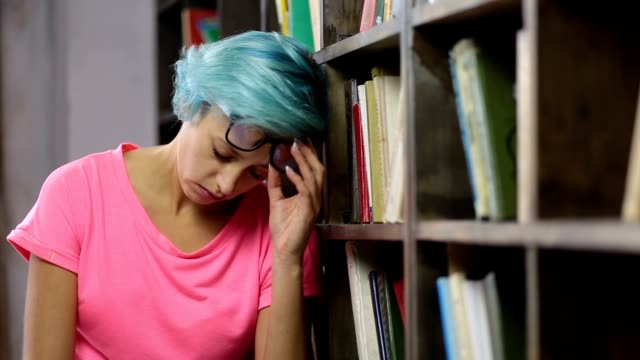 Traurig-Student-unter-psychischen-Druck-in-Bibliothek