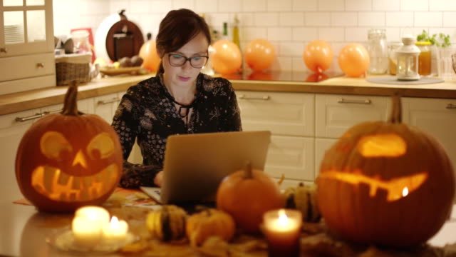 Frau-mit-Laptop-in-der-Nähe-von-Halloween-Dekorationen