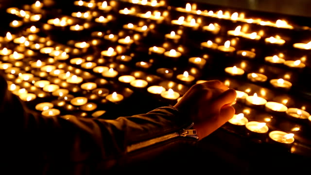 Woman-lighting-round-candles-at-the-church,-religion-and-faith,-spirituality