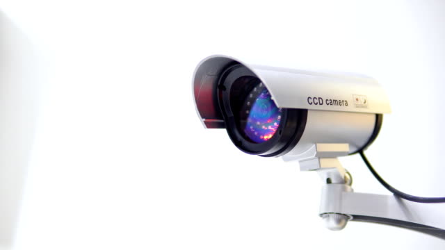The-surveillance-camera-with-flashing-red-light-on-white-background.-Close-up