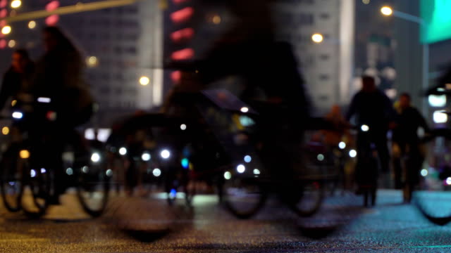 Mucho-paseo-de-ciclistas-en-bicicleta-bicicleta-de-noche,-desfile-de-bicicletas-en-blur-por-calle-de-la-ciudad-de-noche-iluminada.-Multitud-de-gente-en-bicicleta.-Tráfico-de-bicicleta.-Estilo-de-vida-saludable-concepto-de-deporte.-Luces-brillantes.-Vista-de-ángulo-bajo