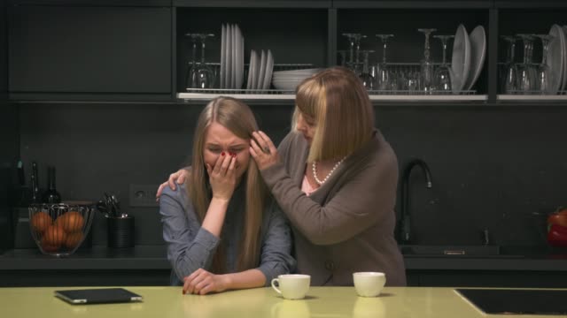 Adult-daughter-crying-and-mother-trying-to-calm-her