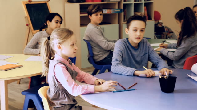 niños-sentados-y-escuchando-el-profesor-en-clase